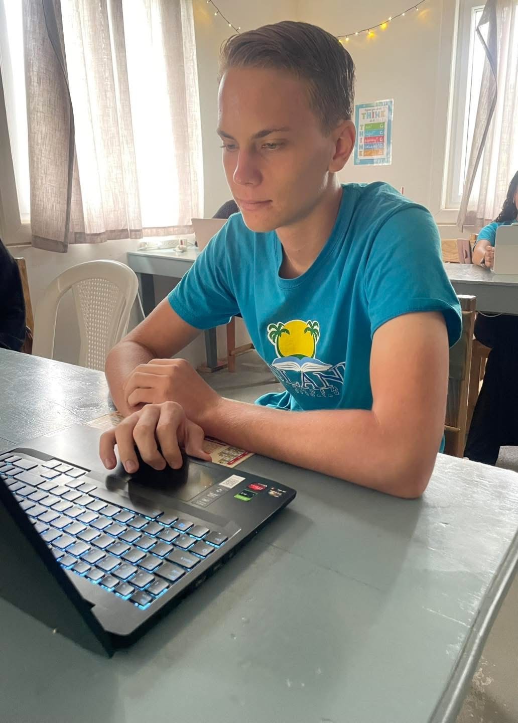 High school student focused on laptop work in the classroom